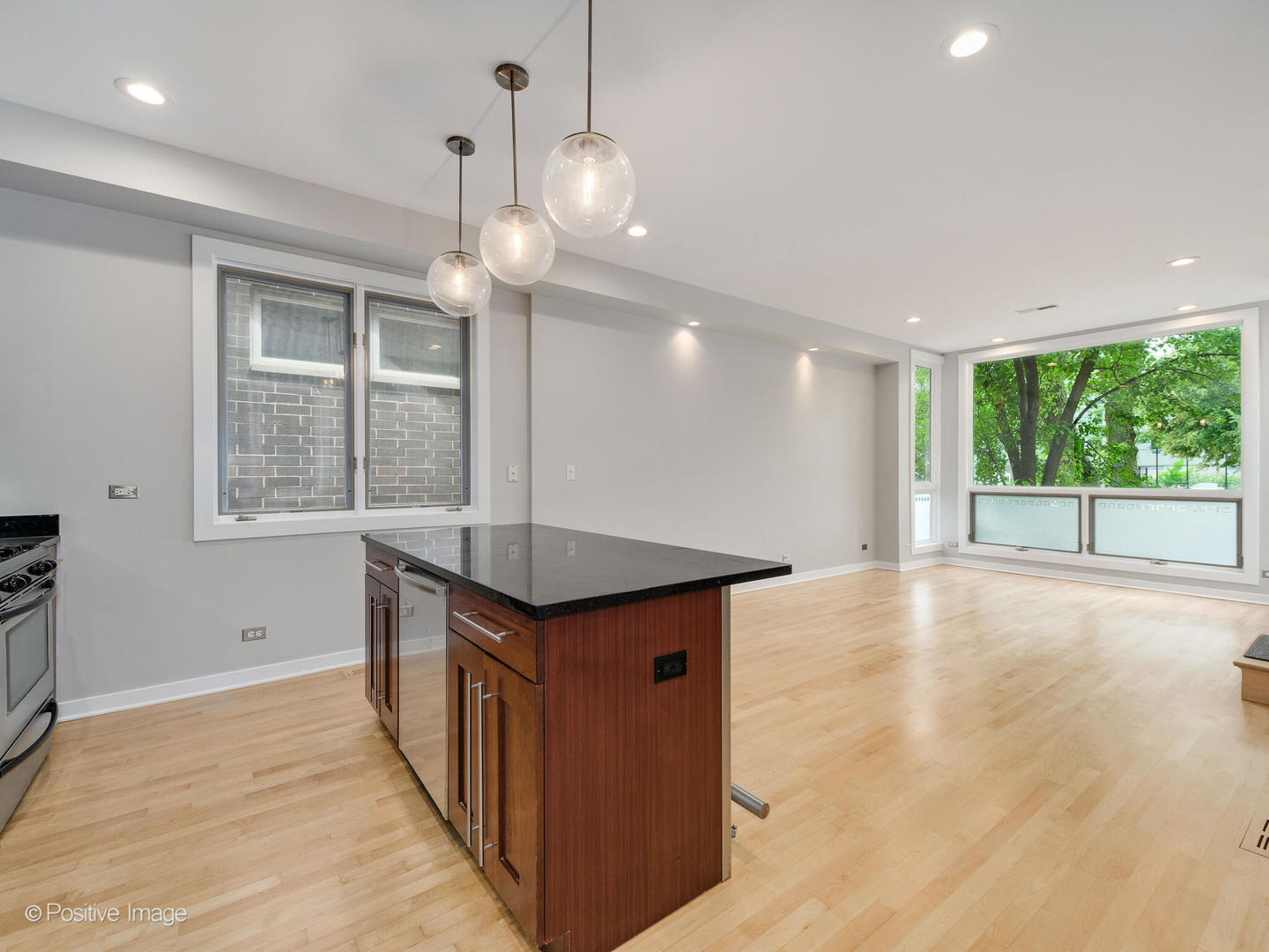 1834 West Rice Street, Unit A Chicago, IL 60622 - Photo 7 of 23 a kitchen with kitchen island a sink wooden floor and a large window