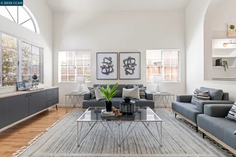 a kitchen with stainless steel appliances granite countertop a stove a refrigerator a sink a stove and white cabinets with wooden floor