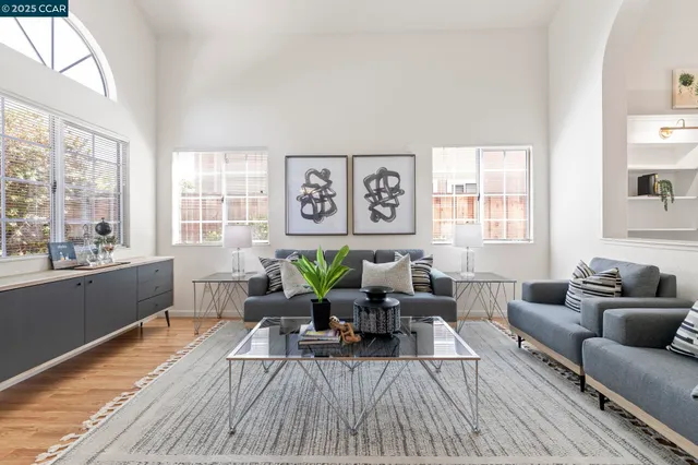 a kitchen with stainless steel appliances granite countertop a stove a refrigerator a sink a stove and white cabinets with wooden floor