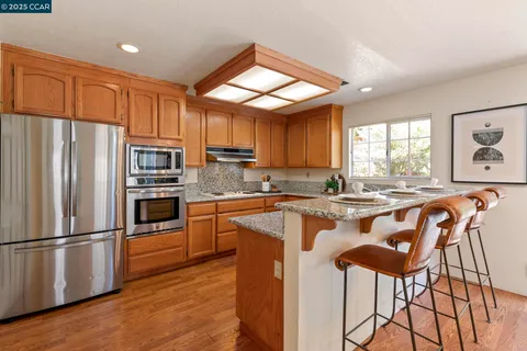 a kitchen with stainless steel appliances granite countertop a stove a sink and a microwave