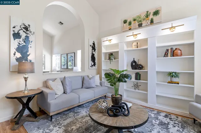 a living room with furniture potted plant and wooden floor