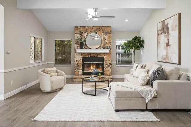 a living room with furniture a fireplace and a chandelier