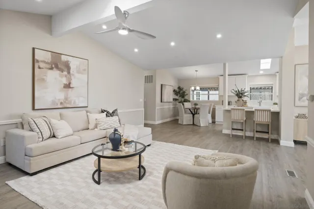 a living room with furniture and a view of kitchen