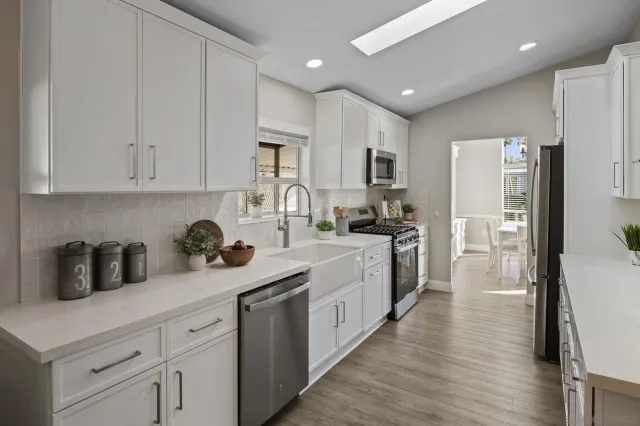 a kitchen with white cabinets and stainless steel appliances