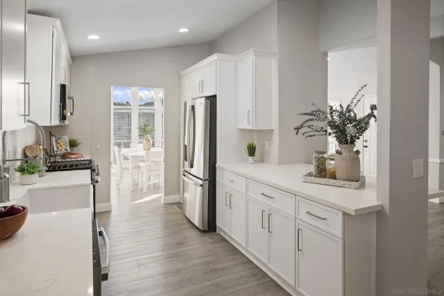 a kitchen with white cabinets and refrigerator