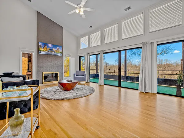 a living room with fireplace furniture and a floor to ceiling window