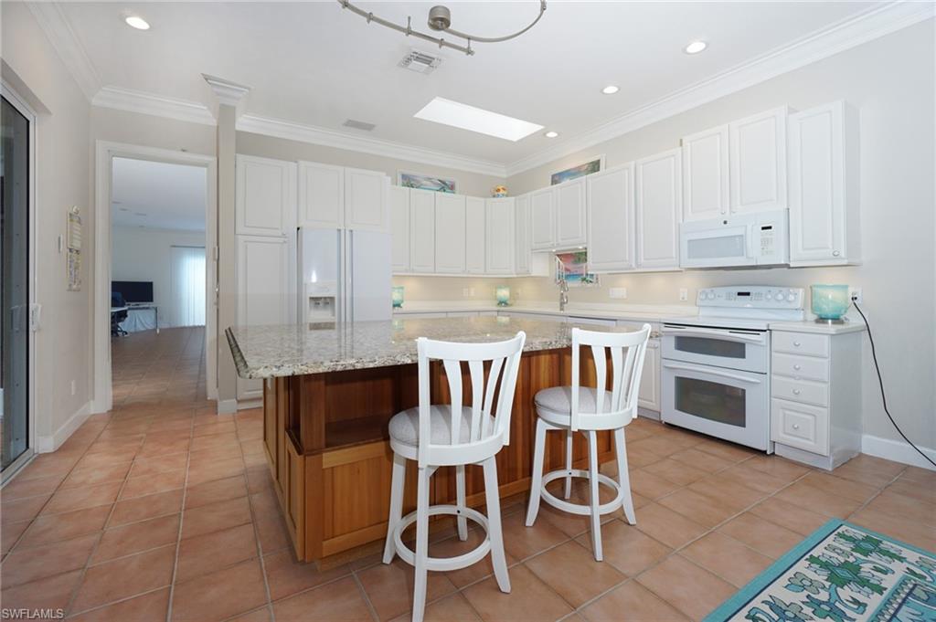 922 Turtle Court Naples, FL 34108 - Photo 8 of 29 a kitchen with granite countertop a dining table chairs stainless steel appliances and cabinets