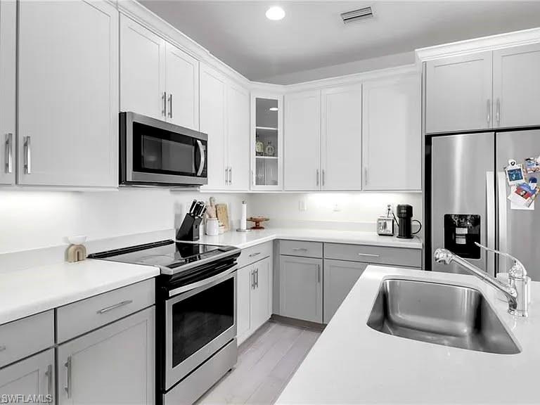 9011 Madrid Circle Naples, FL 34104 - Photo 15 of 20 a kitchen with granite countertop a sink stove and microwave