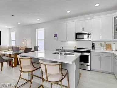 9011 Madrid Circle Naples, FL 34104 - Photo 17 of 20 a kitchen with stainless steel appliances a white table and chairs in it