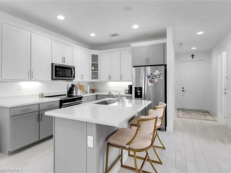 9011 Madrid Circle Naples, FL 34104 - Photo 18 of 20 a kitchen that has a sink a counter top stainless steel appliances and cabinets