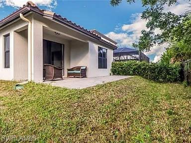 9011 Madrid Circle Naples, FL 34104 - Photo 4 of 20 a front view of a house with a yard
