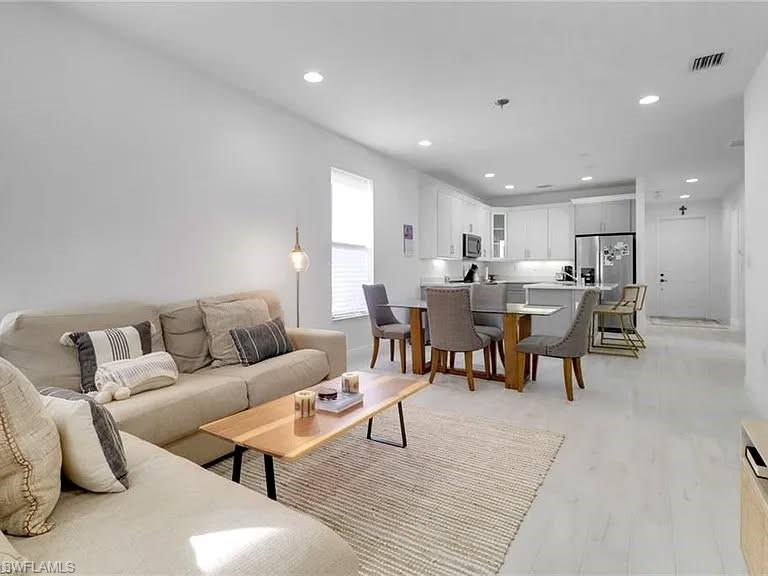 9011 Madrid Circle Naples, FL 34104 - Photo 7 of 20 a living room with lots of furniture and kitchen view
