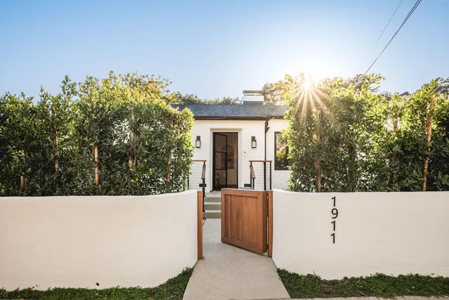 a view of a house with a small yard and potted plants