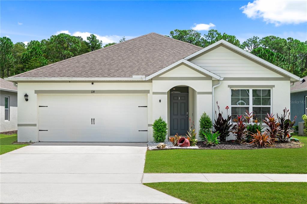 114 Birch Tree Place Daytona Beach, FL 32117 - Photo 1 of 33 a view of a white house with potted plants and a yard