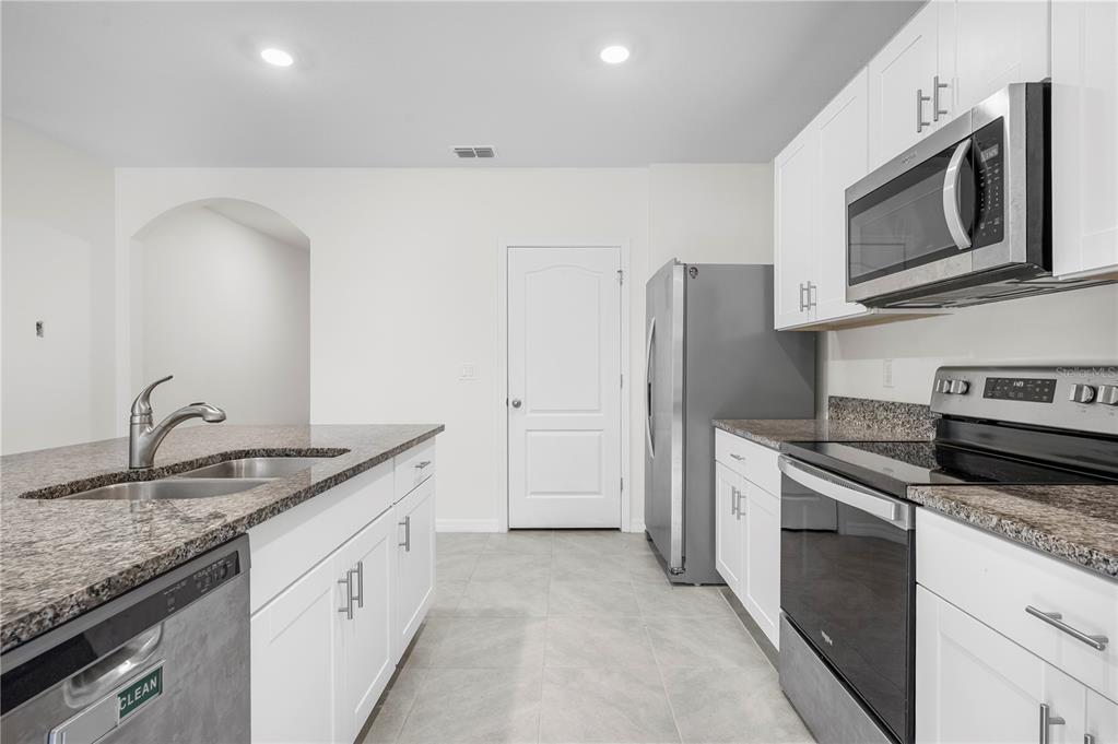114 Birch Tree Place Daytona Beach, FL 32117 - Photo 4 of 33 a kitchen with granite countertop cabinets stainless steel appliances and a counter space