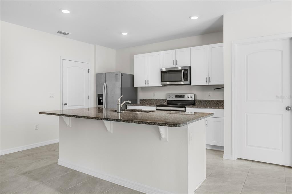 114 Birch Tree Place Daytona Beach, FL 32117 - Photo 6 of 33 a kitchen with stainless steel appliances a sink stove and refrigerator