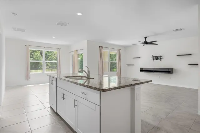 a bathroom with a granite countertop sink a mirror and a bathtub