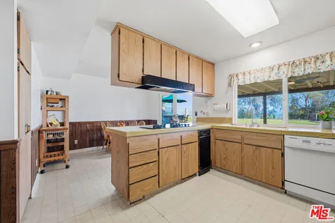 a kitchen with cabinets appliances and a window