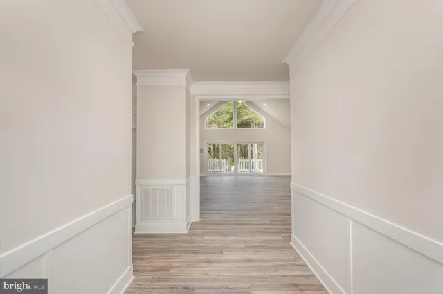 a view of an empty room with a kitchen and a window