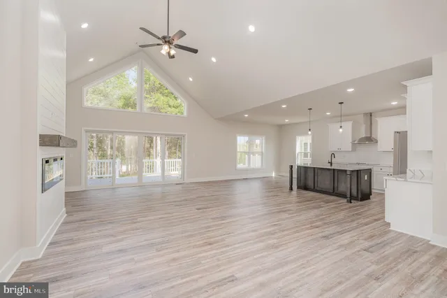 an empty room with wooden floor cabinet and windows