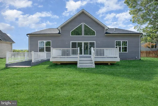 a view of a house with a yard and deck