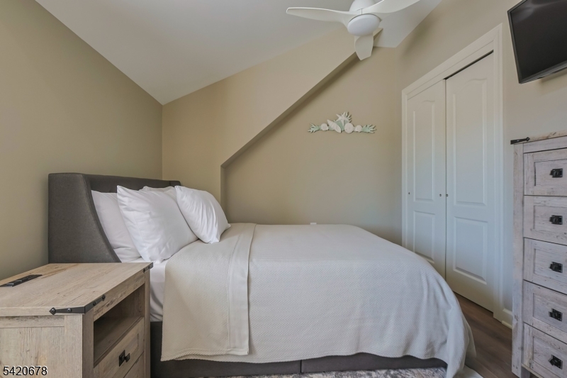 246 Mantoloking Road, Unit 3 Brick, NJ 08723 - Photo 6 of 12 a bedroom with a bed and flat screen tv