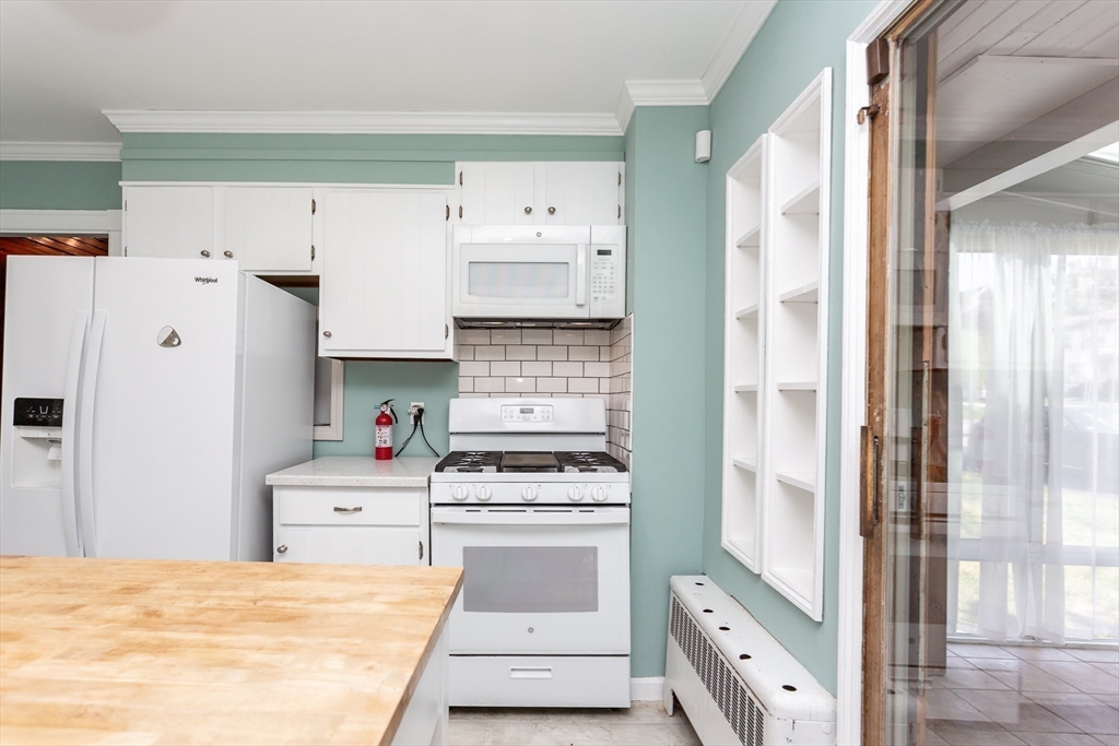 724 High Street Fall River, MA 02720 - Photo 10 of 39 a kitchen with stainless steel appliances a refrigerator and white cabinets