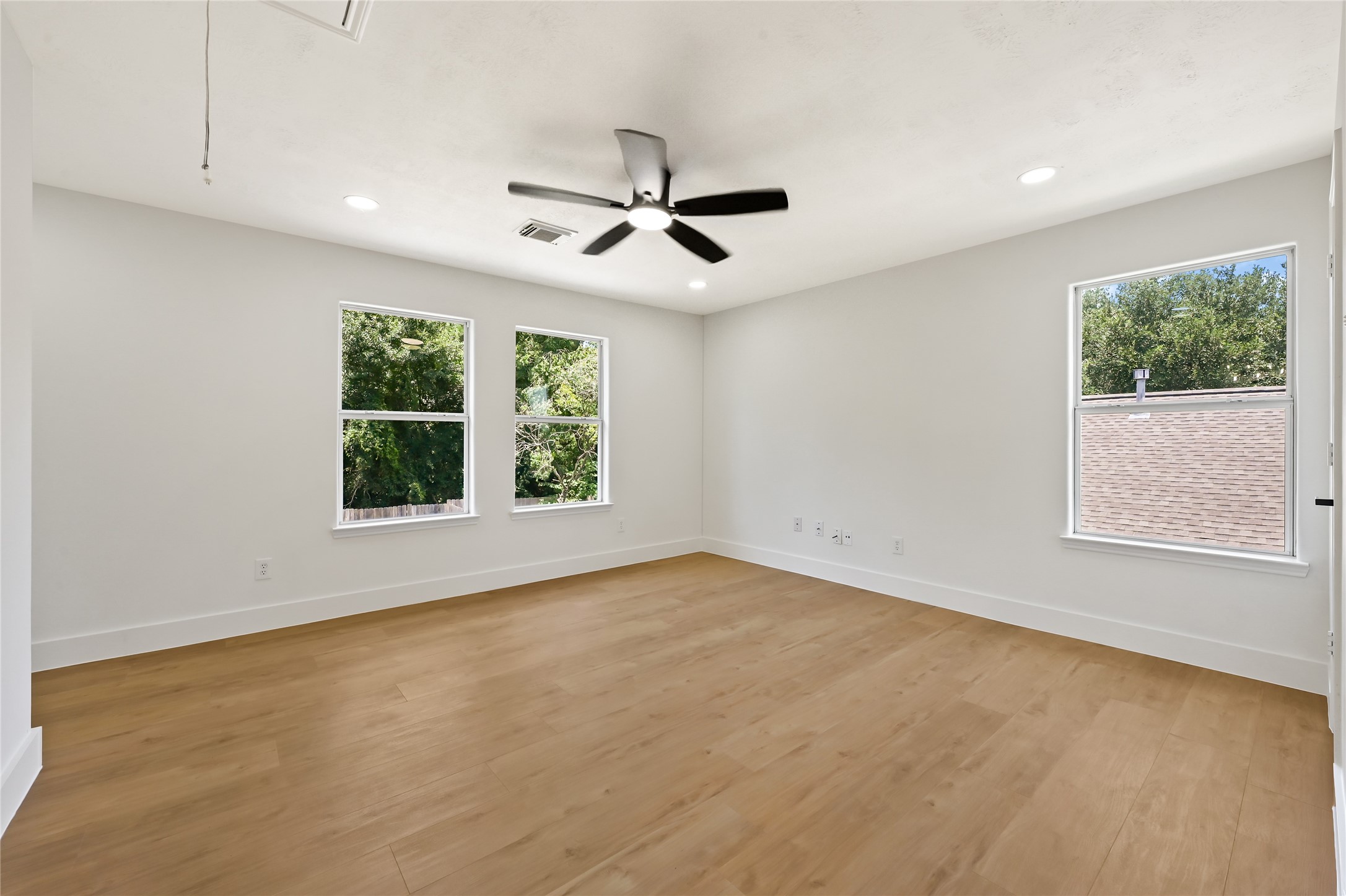 23311 Leafstone Lane Spring, TX 77373 - Photo 14 of 35 Spacious and bright game room with large windows and sleek wood flooring, perfect for entertainment and relaxation.