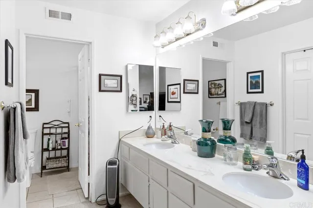 a bathroom with double vanity sinks a vanity and a mirror