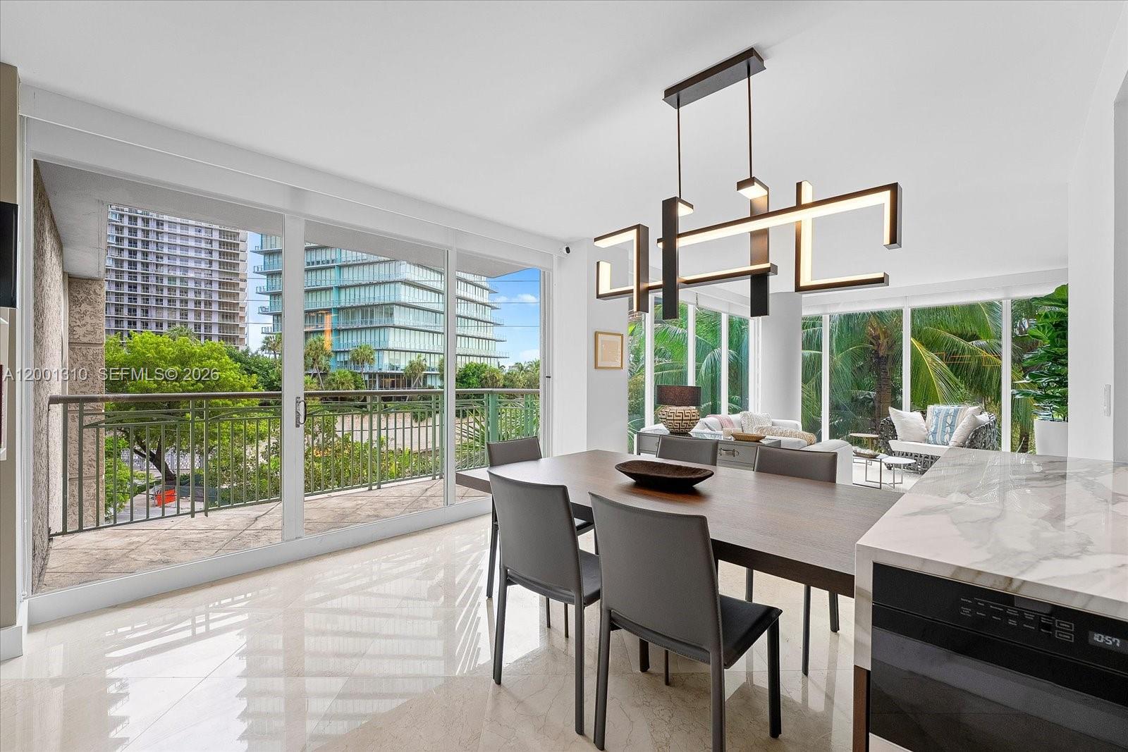 3400 Southwest 27th Avenue, Unit 201 Miami, FL 33133 - Photo 7 of 10 a dining room with wooden floor a chandelier and a floor to ceiling window