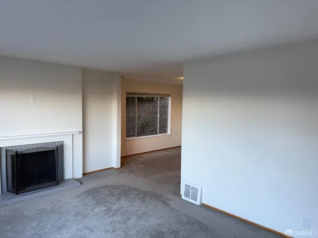 a view of empty room with a fireplace