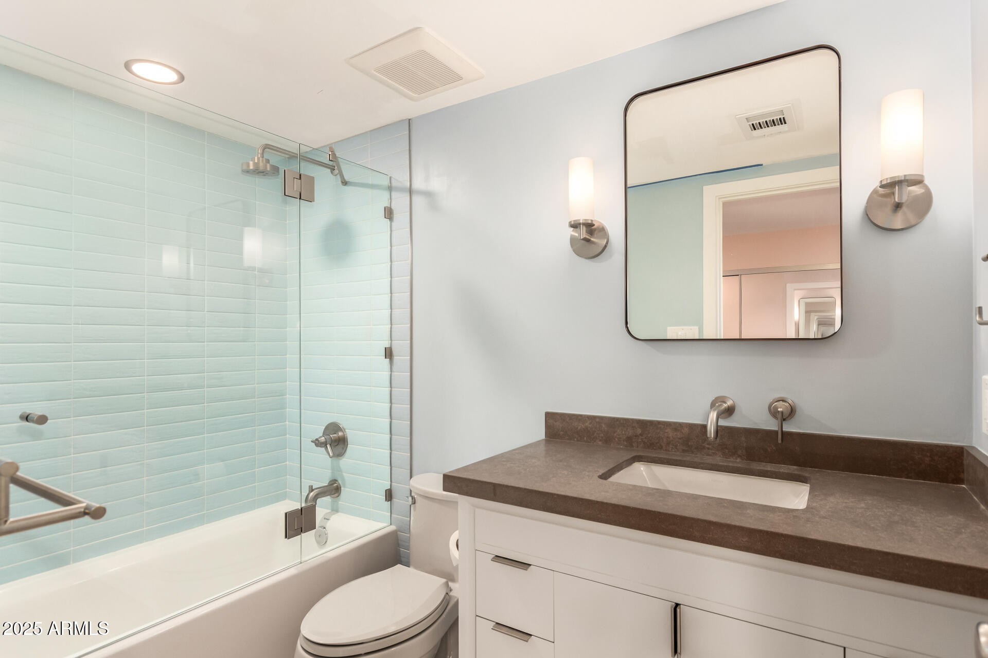 6022 North 10th Way Phoenix, AZ 85014 - Photo 26 of 40 a bathroom with a granite countertop sink toilet a mirror and shower