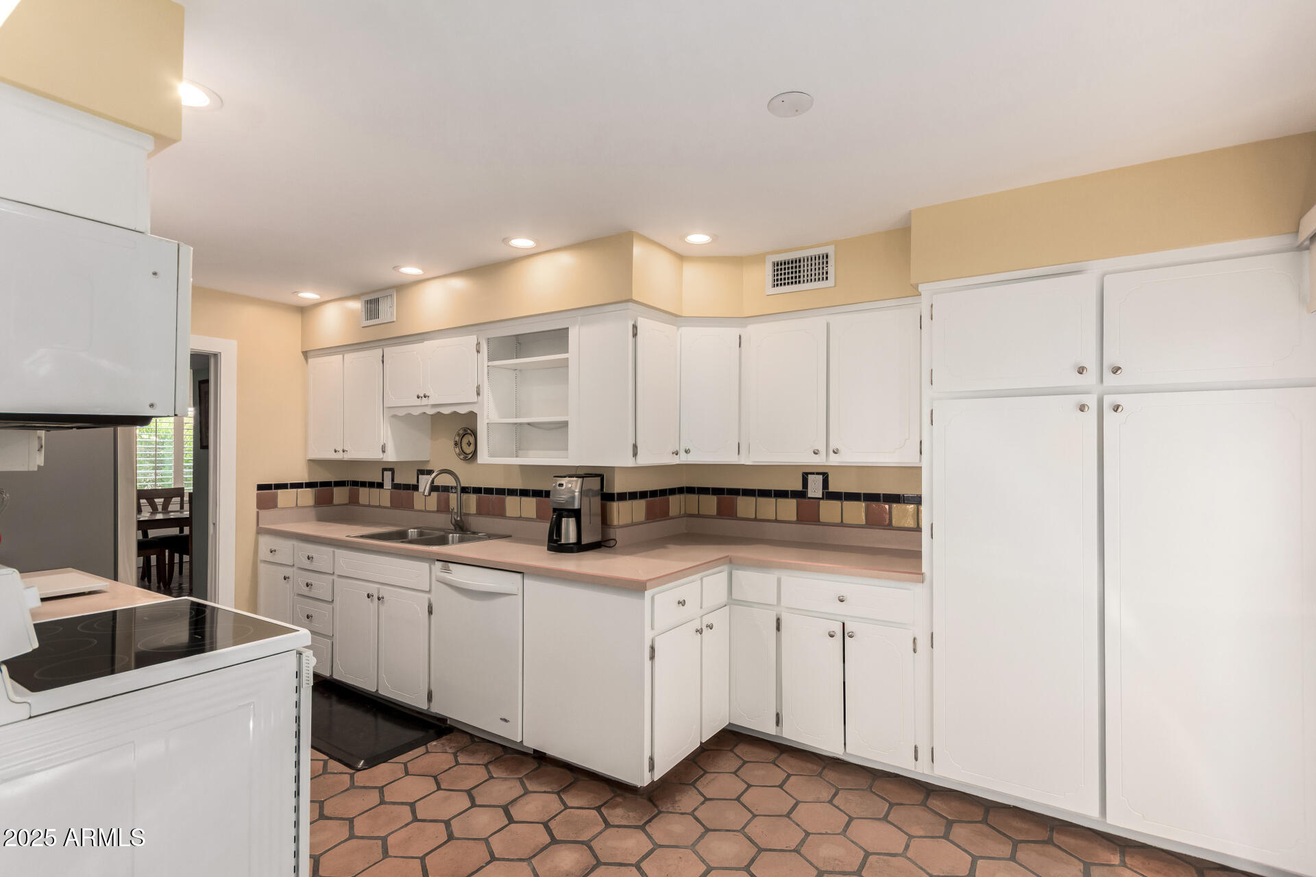 6022 North 10th Way Phoenix, AZ 85014 - Photo 9 of 40 a kitchen with white cabinets sink and white appliances