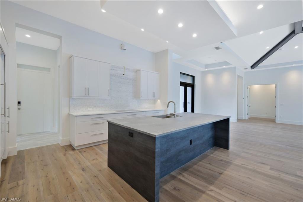 16743 Enclave Circle Naples, FL 34110 - Photo 12 of 42 a kitchen with a sink and a refrigerator