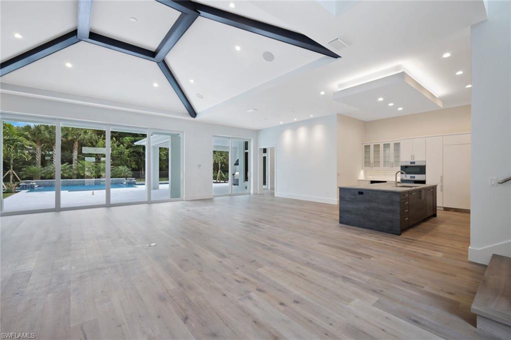 16743 Enclave Circle Naples, FL 34110 - Photo 13 of 42 a large hall with stainless steel appliances granite countertop a large counter top a sink with wooden floor