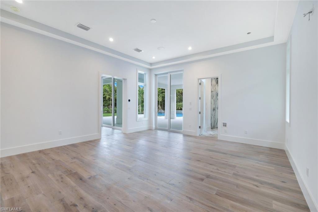 16743 Enclave Circle Naples, FL 34110 - Photo 14 of 42 a view of an empty room with wooden floor