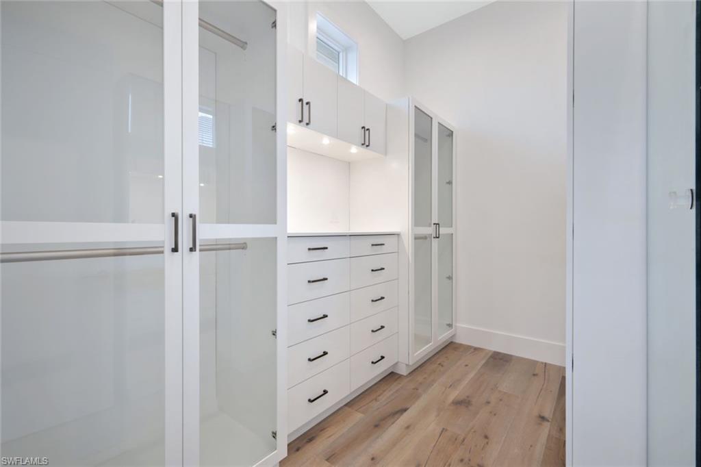 16743 Enclave Circle Naples, FL 34110 - Photo 17 of 42 walk in closet with wooden floor