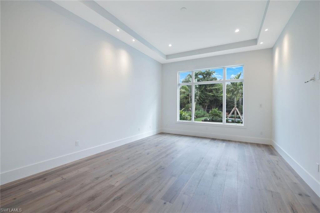 16743 Enclave Circle Naples, FL 34110 - Photo 18 of 42 wooden floor in an empty room with a window