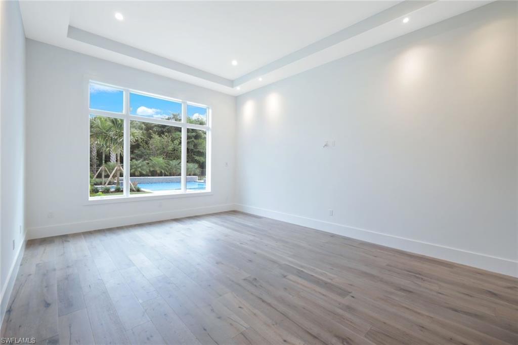 16743 Enclave Circle Naples, FL 34110 - Photo 19 of 42 a view of an empty room with wooden floor and a window