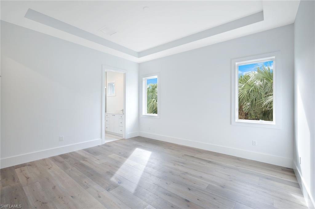 16743 Enclave Circle Naples, FL 34110 - Photo 22 of 42 an empty room with wooden floor and windows
