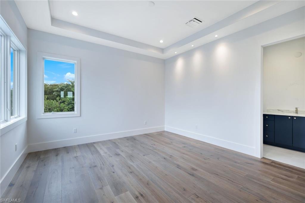 16743 Enclave Circle Naples, FL 34110 - Photo 24 of 42 a view of an empty room with wooden floor and a window