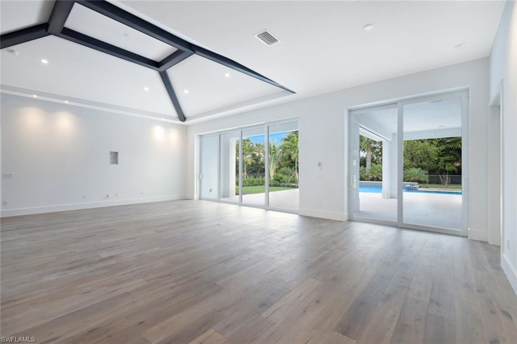 16743 Enclave Circle Naples, FL 34110 - Photo 5 of 42 a view of an empty room with wooden floor and windows