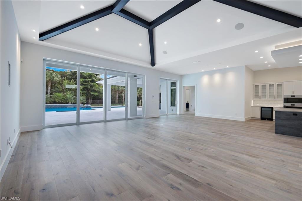 16743 Enclave Circle Naples, FL 34110 - Photo 6 of 42 a view of an empty room with wooden floor and a window