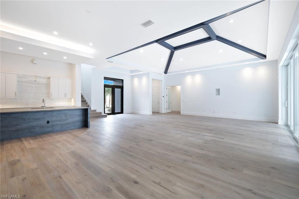 16743 Enclave Circle Naples, FL 34110 - Photo 8 of 42 a view of an empty room with wooden floor and a window