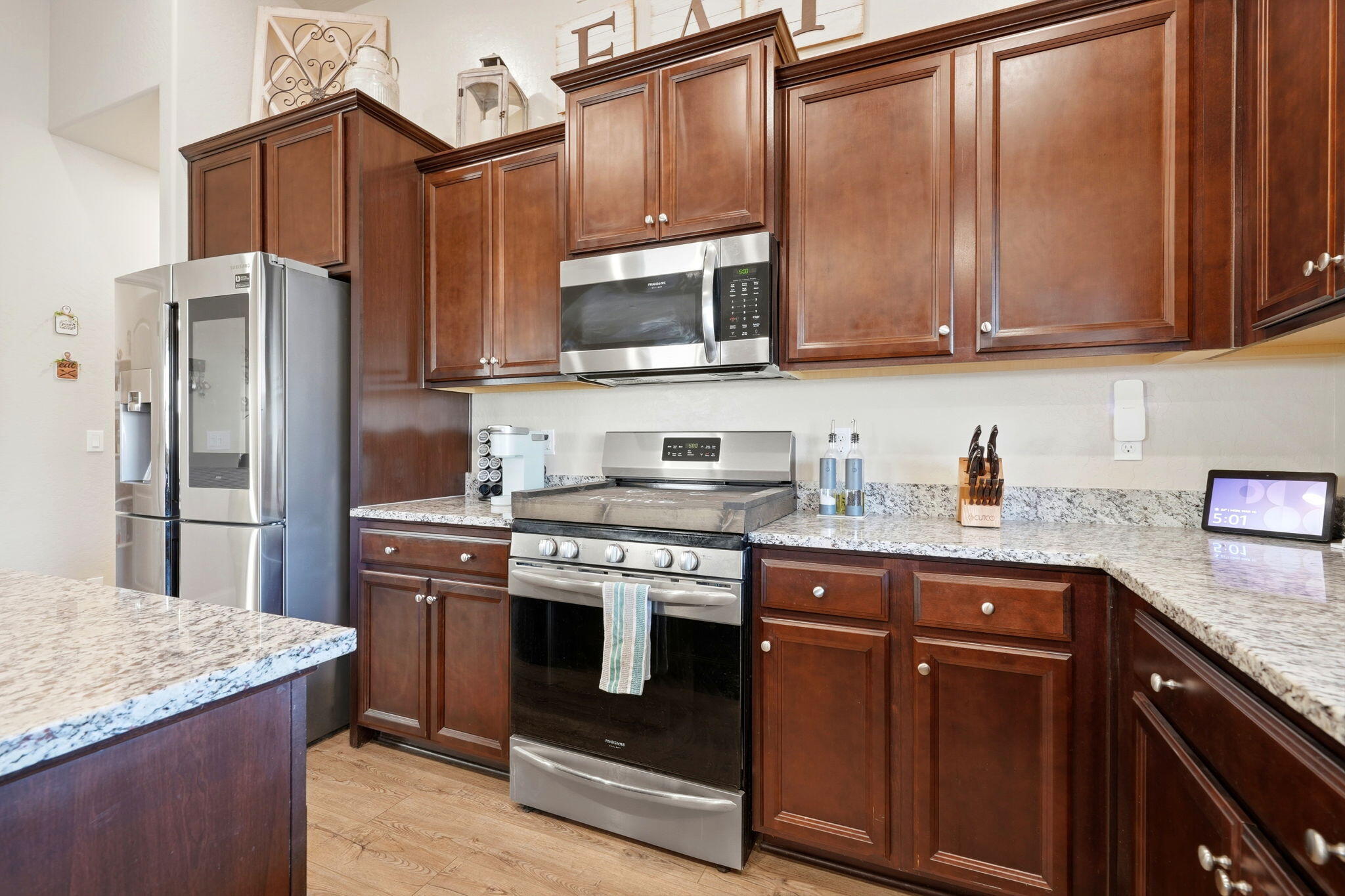 756 Strada Street Lemoore, CA 93245 - Photo 15 of 53 a kitchen with stainless steel appliances granite countertop wood cabinets a refrigerator and a sink