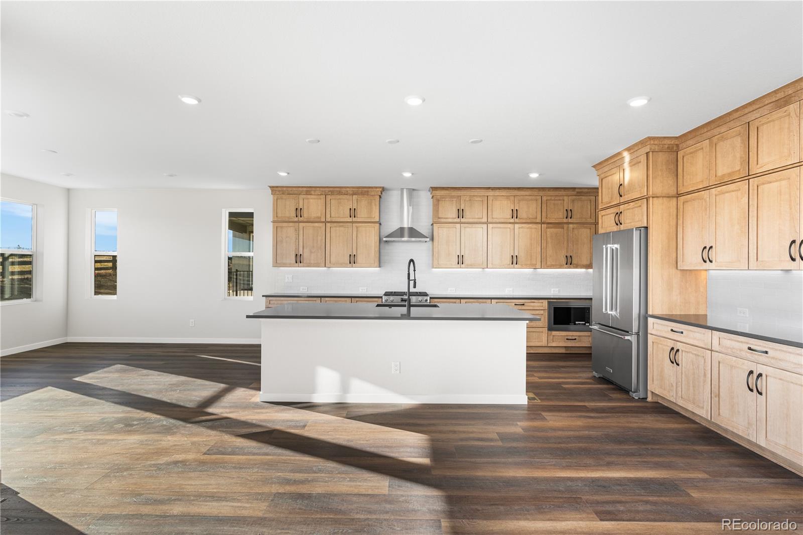 1250 Bridgefield Road Castle Pines, CO 80108 - Photo 12 of 33 a kitchen with stainless steel appliances kitchen island granite countertop a refrigerator and a stove top oven