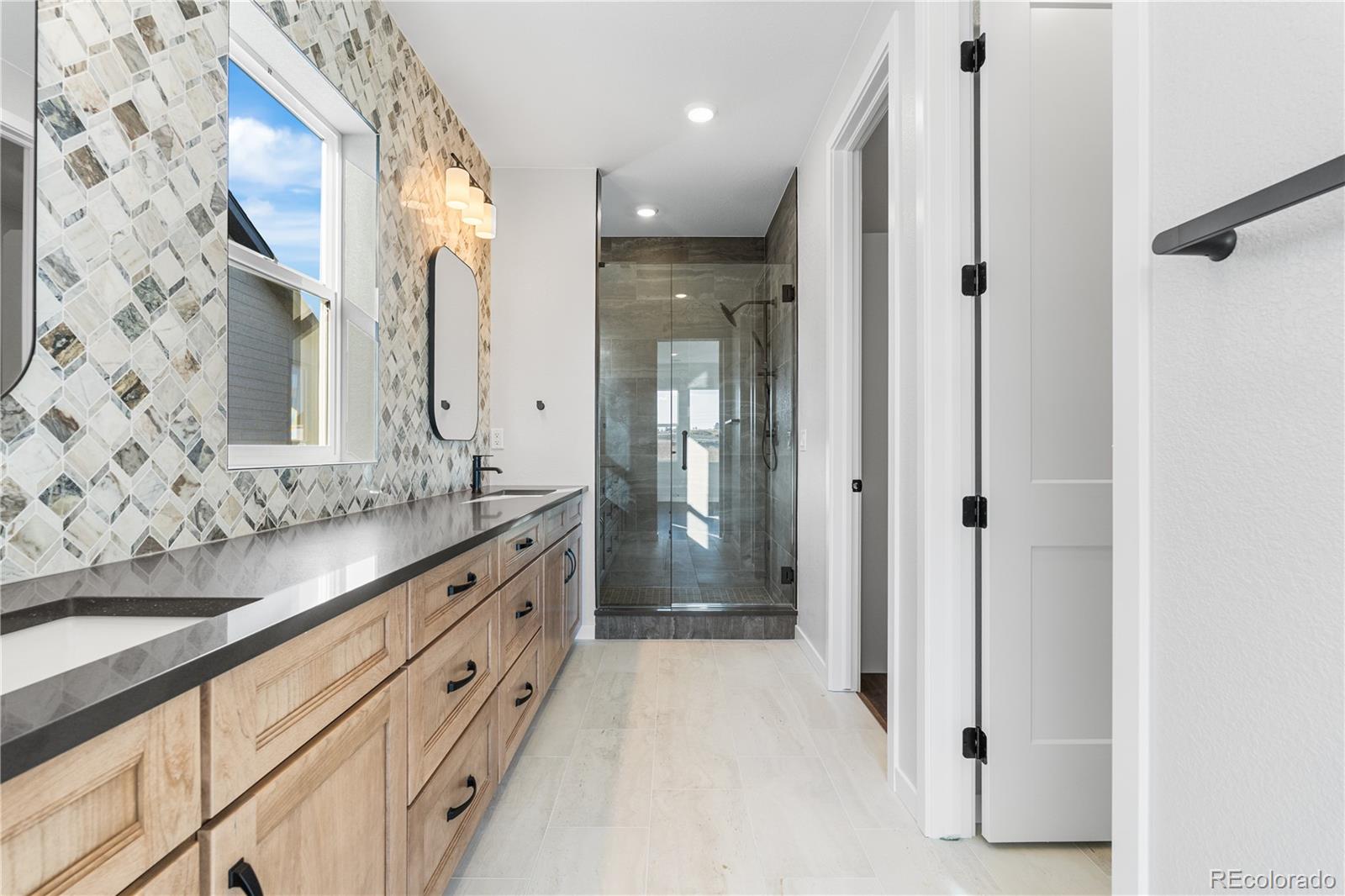 1250 Bridgefield Road Castle Pines, CO 80108 - Photo 25 of 33 a bathroom with a double vanity sink and mirror with shower