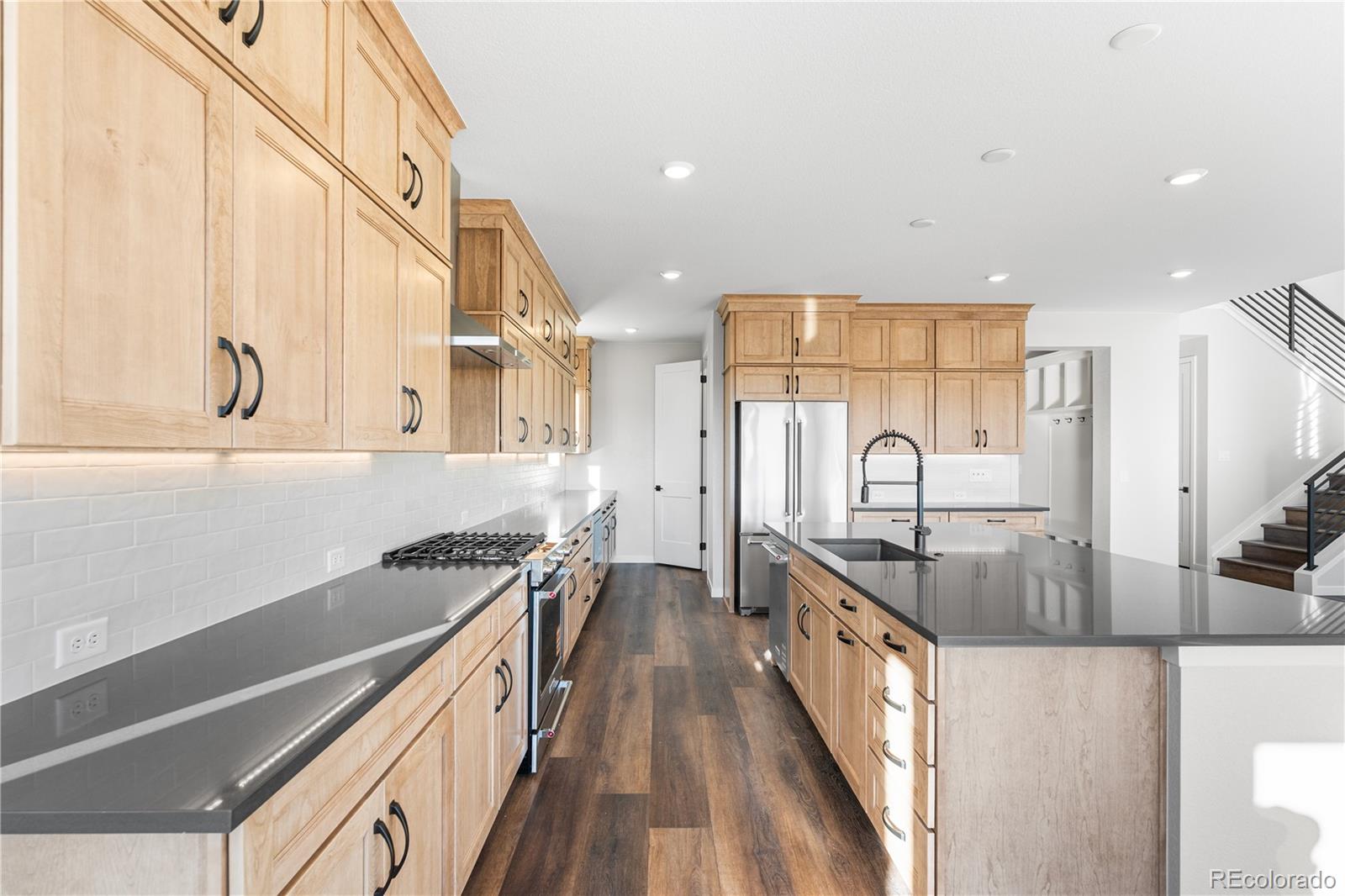 1250 Bridgefield Road Castle Pines, CO 80108 - Photo 10 of 33 a kitchen with stainless steel appliances granite countertop a stove a sink and a refrigerator