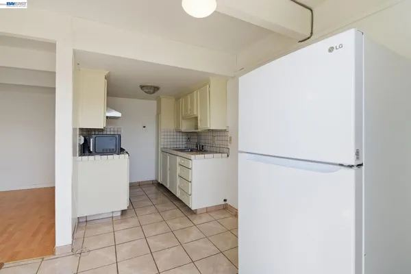a kitchen with a refrigerator a stove top oven and cabinets