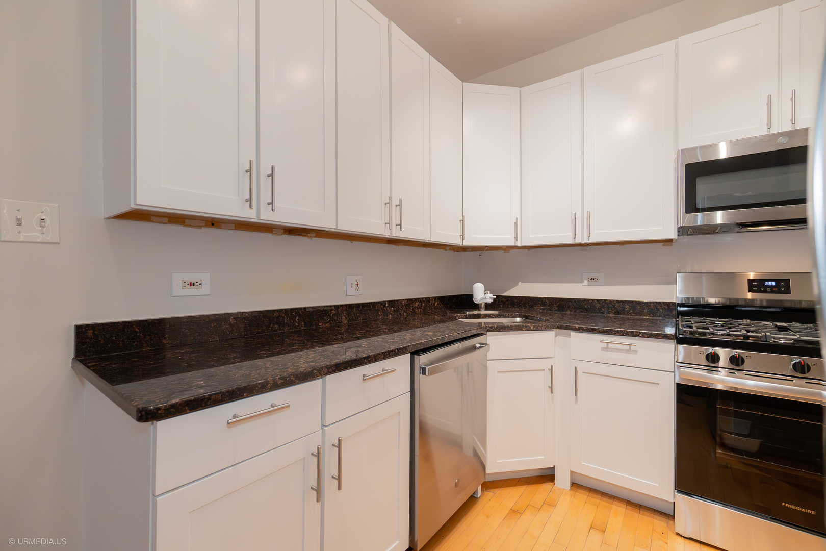 728 West Sheridan Road, Unit 1S Chicago, IL 60613 - Photo 9 of 19 a kitchen with granite countertop white cabinets and stainless steel appliances